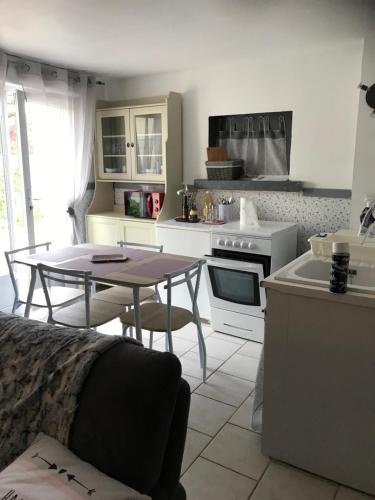 une cuisine avec une table et une cuisine avec une cuisinière dans l'établissement joli studio au coeur de Verdun, à Verdun-sur-Meuse