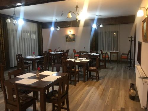 a dining room with tables and chairs and lights at Pensiunea Valea Pinului in Rau Sadului