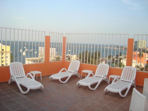 four chairs on a balcony with a view of the city at Hotel Posada del Carmen in Veracruz