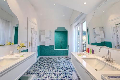 a bathroom with two sinks and a tub at Grand Hotel Ambasciatori in Sorrento