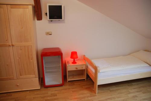 a bedroom with a bed and a table with a red lamp at In Vino Bed & Breakfast in Pohořelice