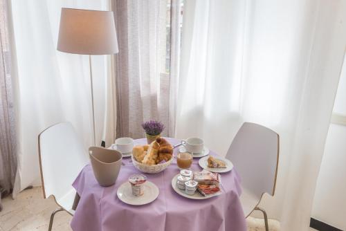 a table with a purple table cloth and food on it at Hotel Villa Nicole in Pietra Ligure