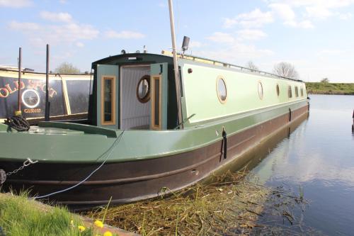 una barca è ormeggiata in acqua su un fiume di Cambridge Boat Hire a Chesterton