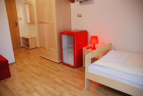 a room with a red refrigerator and a bed at In Vino Bed & Breakfast in Pohořelice