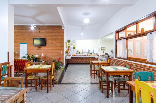 a dining room with wooden tables and chairs at Pousada Vivamar in Ubatuba