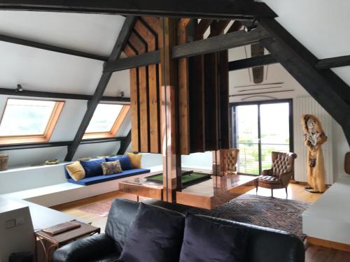 un salon avec un canapé et quelques fenêtres dans l'établissement Chez Jeanne, à Plounéour-Trez