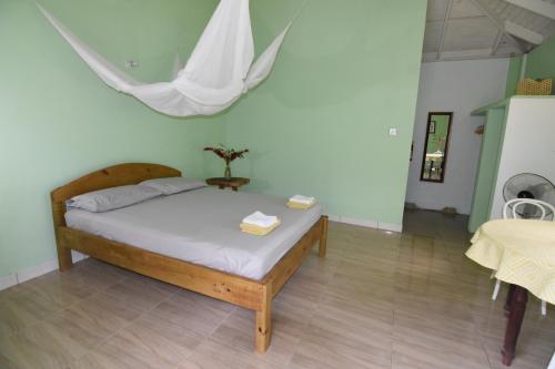 a bedroom with a bed and a table at Soufriere Guesthouse in Soufrière