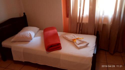 a bed with a red blanket and towels on it at Archontiko tou Krommyda in Elati Trikalon