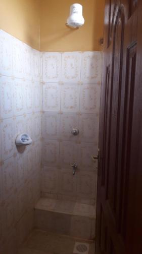 a bathroom with a shower with a tub and a toilet at Bondo Travellers Hotel in Bondo