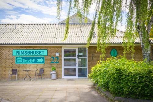 a brick building with a sign in front of it at Djurs-BnB - Rimsøhuset in Rimsø