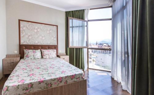a bedroom with a bed and a large window at Apartament on Rustaveli in Batumi