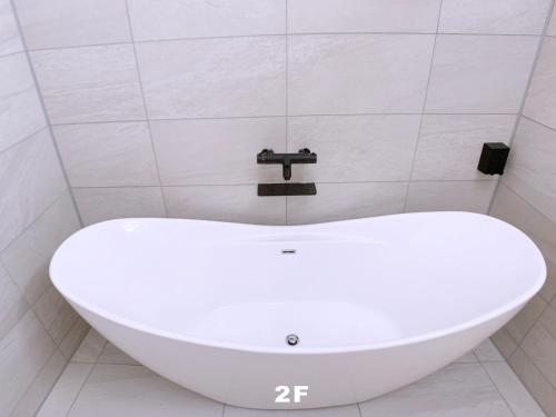 a white bath tub in a bathroom with a faucet at HAKU HOTEL in Tokyo