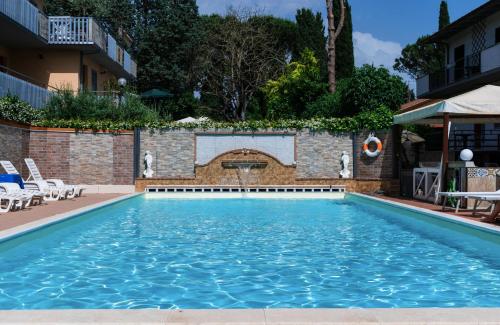 a swimming pool in a hotel with a brick wall at Residence Al Lago in Castiglione del Lago