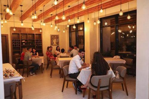 a group of people sitting at tables in a restaurant at Hotel Miki in Durrës