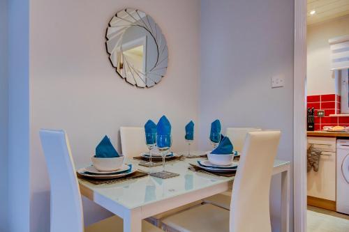 a dining room with a table and chairs and a mirror at No 7 Ayr Beach - Coorie Doon in Ayr