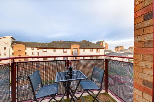 a balcony with two chairs and a table on a balcony at No 7 Ayr Beach - Coorie Doon in Ayr