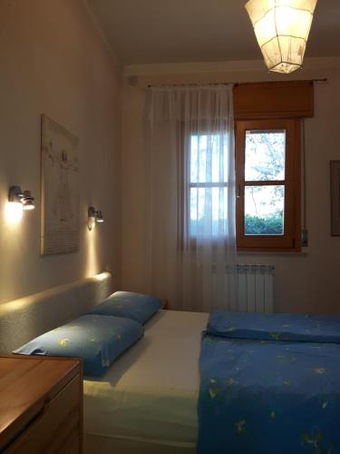 Un dormitorio con una cama con almohadas azules y una ventana. en Tenuta Tufo nel Blu, en Maruggio