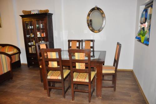 a dining room table with four chairs and a mirror at Alegria in Eşelniţa