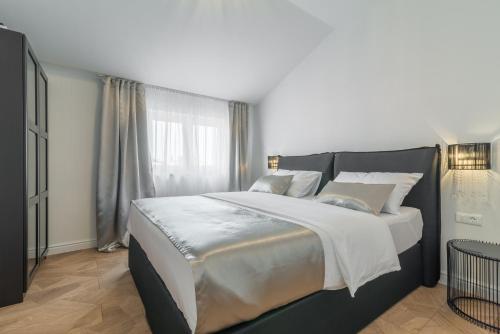 ein Schlafzimmer mit einem großen Bett und einem Fenster in der Unterkunft Luxury Piano apartment in Zadar