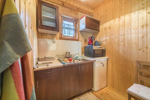 a small kitchen with a sink and a refrigerator at Domki Lena Kopalino in Kopalino