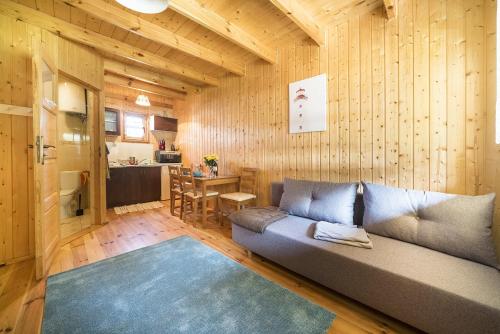 a living room with a couch and a kitchen at Domki Lena Kopalino in Kopalino