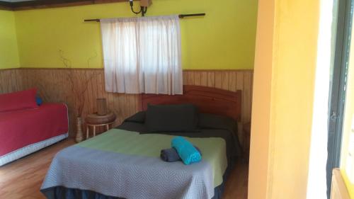 a small bedroom with a bed and a window at Cabañas Maria Hau in Hanga Roa