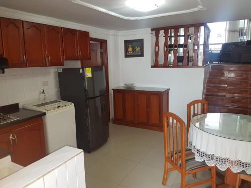 a kitchen with a table and a black refrigerator at Apto en Rodadero Palanoa 605 Dos Habitaciones 7 personas in Santa Marta