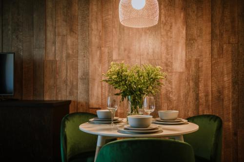 a table with chairs and a vase of flowers on it at ERTA Anykščių Namai in Anykščiai