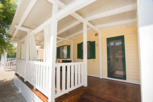 a front porch of a house with a white railing at Sunce Mobile Homes & apartments in Grebaštica