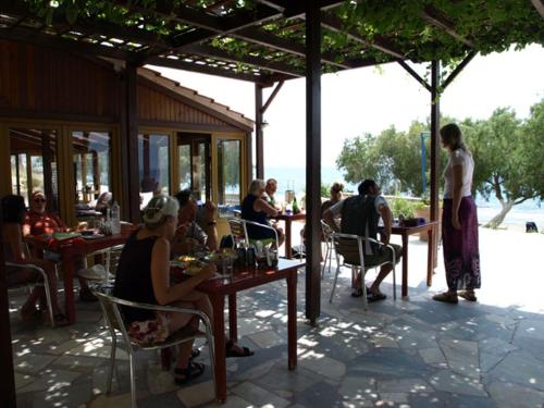 a group of people sitting at tables in a restaurant at Alexander Beach Hotel in Kalamaki