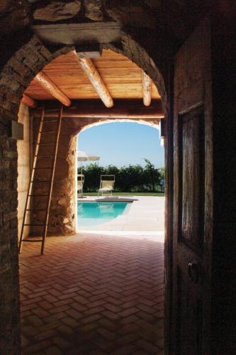 an archway leading to a swimming pool with a ladder at B&B Al Cristo in SantʼAmbrogio di Valpolicella