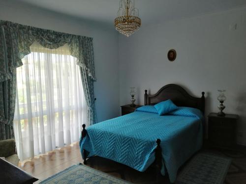 Un dormitorio con una cama y una ventana grande en Vivenda Ribeiro, en Lagos