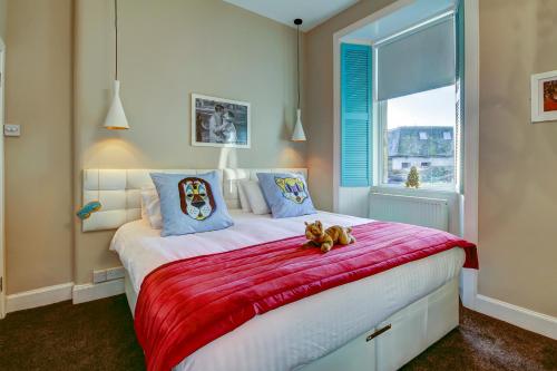 a teddy bear sitting on a bed in a bedroom at Tiffanys - Coorie Doon Stays in Prestwick
