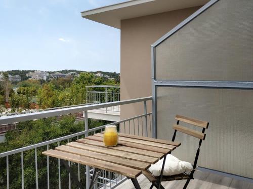 a wooden table on a balcony with a candle on it at Lilly Apartments in Athens