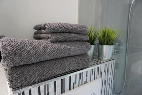 una pila de toallas en un estante del baño en Davos Holiday Apartment, en Davos
