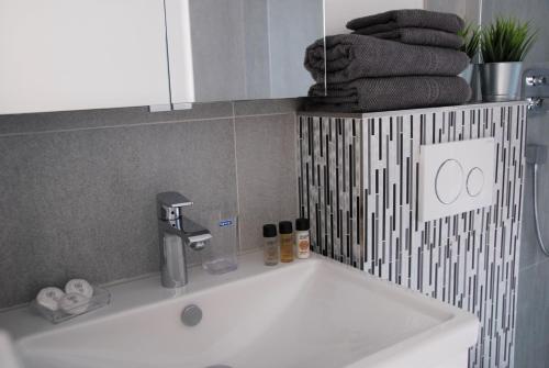 a white sink in a bathroom with a counter top at Davos Holiday Apartment in Davos