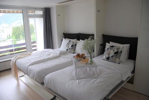 2 camas individuales en una habitación con ventana en Davos Holiday Apartment en Davos