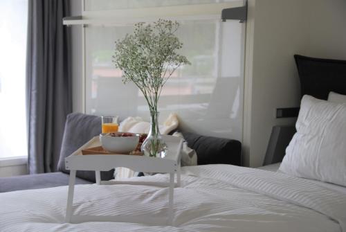 a table with a vase of flowers on a bed at Davos Holiday Apartment in Davos