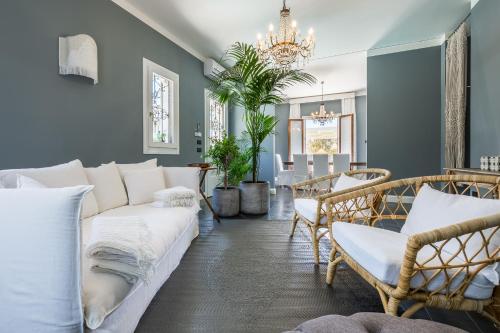 a living room with a white couch and chairs at Villa Raphael in Avola
