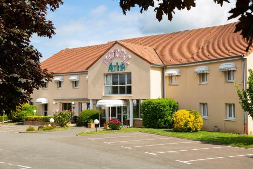 a hotel with a parking lot in front of it at Logis Hotel Altina in Pacy-sur-Eure