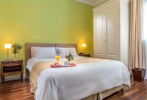 a bedroom with a white bed with two glasses of wine at 248 Finisterra in Buenos Aires