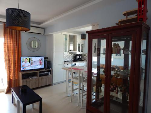 a kitchen and living room with a table and a television at Christina-2 in Perea