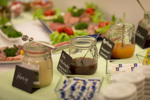 a table topped with jars of honey and vegetables at Hotel Emmerich in Winningen