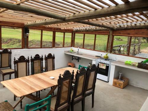 an open kitchen with a wooden table and chairs at Valle de Domos - Minas in Minas