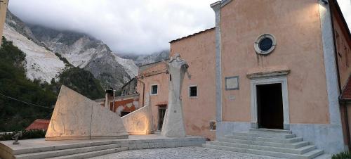 a building with a staircase in front of a mountain at L ' CANTON B & B in Colonnata