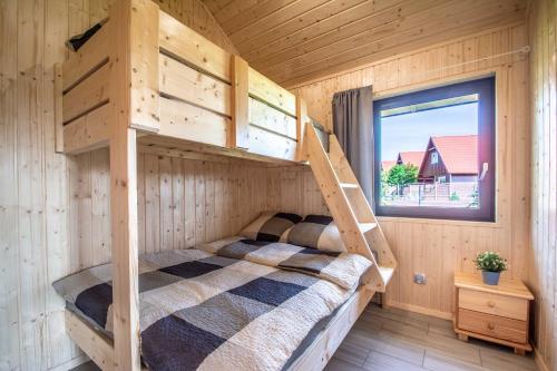 a bedroom with a bunk bed in a log cabin at Ustecka Osada - Ustka (Przewłoka) in Ustka
