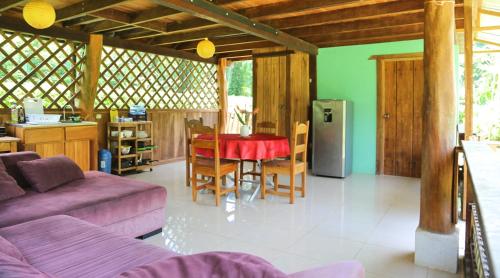 a living room with a couch and a table with chairs at Hotel & Cabinas Nadine in Cahuita