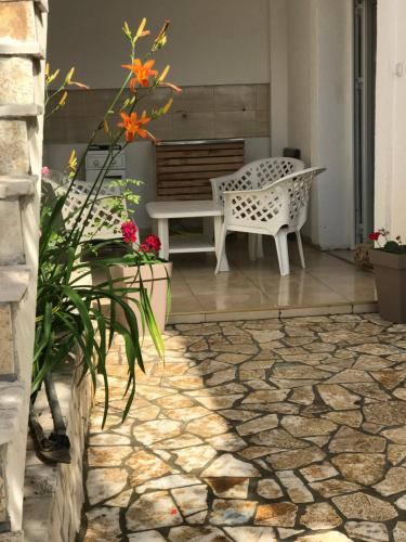 a patio with a bench and a table and flowers at Suka Apartments in Ulcinj