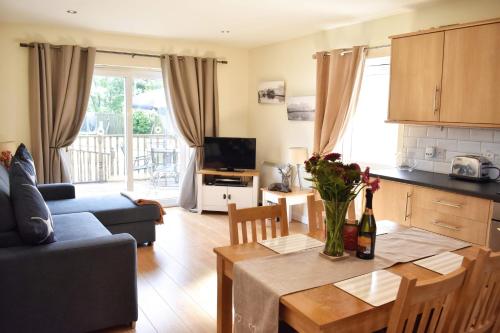 a kitchen and living room with a table and a couch at Ramblers Rest Modern Cottage-Perfect Views of Ben Nevis in Fort William