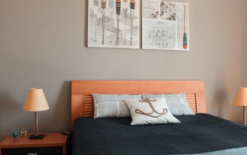 a bedroom with a bed with a wooden headboard and two lamps at Lovely oceanview beach house in Portimão